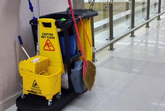 Janitorial and mop bucket on cleaning in process with copy space indoor.